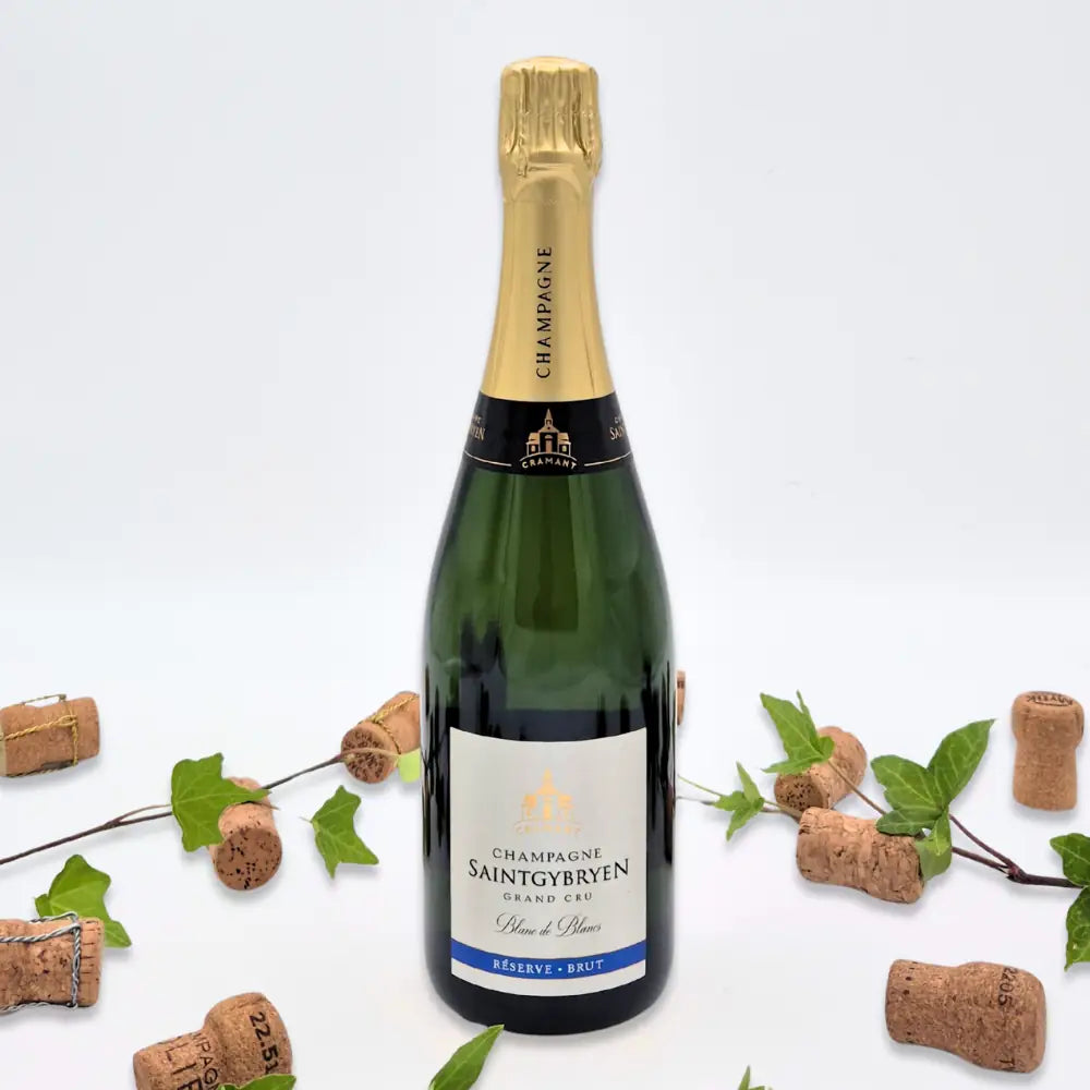 Réserve Brut omgivet af vinkorker, grønne blade på hvid baggrund.