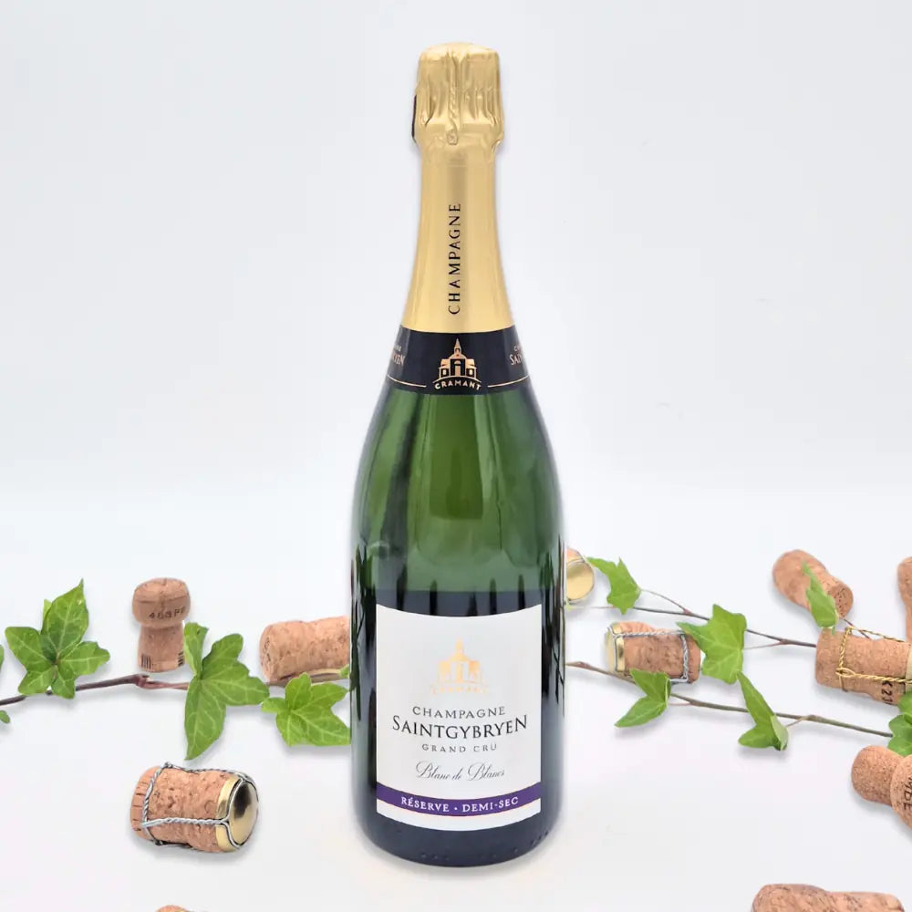 Réserve Demi-sec omgivet af vinkorker, grønne blade på hvid baggrund.